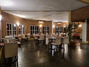 una sala da pranzo con tavoli, sedie e pareti in mattoni di La Barraca Resort a Merlo