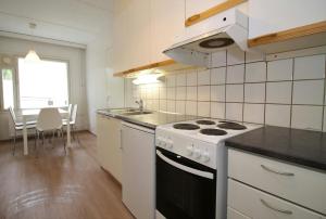 a kitchen with a stove and a sink at Spacious Apartment for 4 with Sauna in Salo