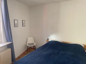 a bedroom with a blue bed and a chair at Apartment im Scheffelhaus in Gengenbach