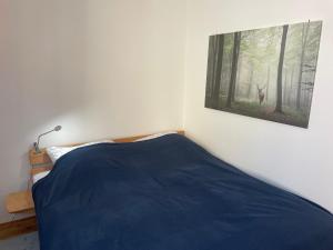 a bedroom with a blue bed and a picture of a deer at Apartment im Scheffelhaus in Gengenbach +6 photos