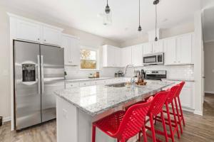 Mount HollyにあるCharming 3BR Belmont Bungalowのキッチン(白いキャビネット、赤いバースツール付)