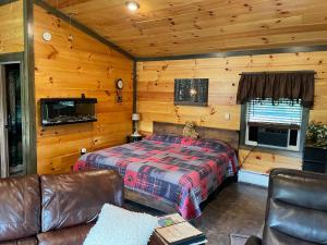 a bedroom with a bed and a couch in a cabin at Lily Pad Cabin in South Park