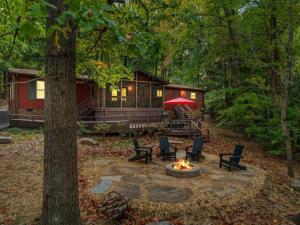 Una cabaña en el bosque con una fogata en Warm Days and Cool Knights Fire Pit Boat Rental, en Mayhew