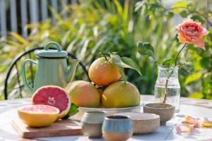 a table with a plate of fruit and a vase with a flower at Restart Ramot-ריסטארט צימר ברמות in Moshav Ramot