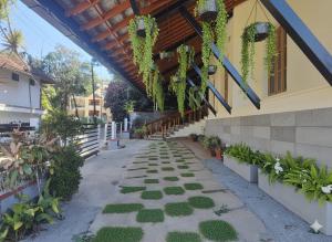 ein Gehweg vor einem Gebäude mit Pflanzen in der Unterkunft Coffee cottage guest house in Madikeri