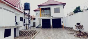 a large white house with a blue garage at EvP in Kumasi