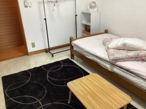 a room with a bed and a table and a rug at Ichigoso - Vacation STAY 19650 in Ichihara