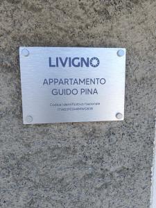 een bord aan de zijkant van een gebouw bij Appartamento Guido Pina in Livigno