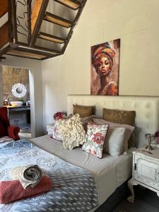 Un dormitorio con una cama con un cuadro en la pared. en casa bella, en Hartbeespoort 49 fotos más