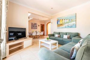 Una sala de estar con un sofá y un televisor. en Villa Manuel by Villa Plus, en Son Parc