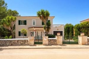 a house with a gate and a palm tree at Villa Manuel by Villa Plus in Son Parc
