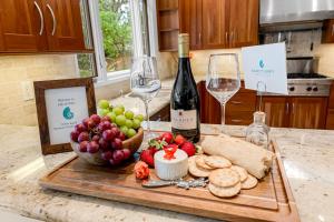 a cutting board with wine and grapes and bread and wine glasses at 3984 Life of Riley home in Del Monte Forest