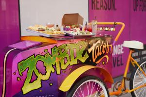 a purple food truck with a bike parked next to it at Moxy Louisville Downtown in Louisville