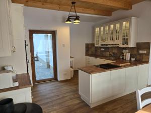 a kitchen with white cabinets and a wooden floor at Chalupa Svratouch36 in Svratouch