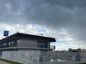 夏延Motel 6 Cheyenne, WY的一栋前面有白色围栏的建筑