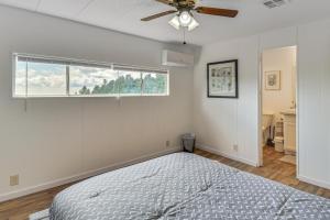 a bedroom with a bed and a ceiling fan at Mtn-View Coulter Escape w/ Rustic Tree Lookout in Coulterville