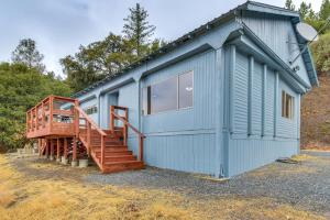 a blue tiny house with a wooden staircase at Mtn-View Coulter Escape w/ Rustic Tree Lookout in Coulterville
