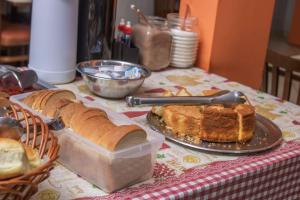 a table topped with bread and a plate of cake at Campos Gerais Hotel - Próximo a Rodoviária e Mercados Turísticos in Belo Horizonte +57 photos