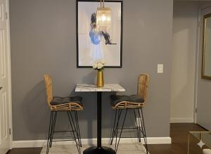 a table with two chairs and a vase with flowers at West Village Lush Green in New York