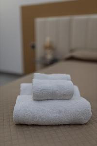 quattro asciugamani sono impilati sopra un letto di Fiera & Luna appartament a Catania