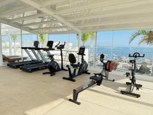 a gym with a bunch of treadmills and cardio machines at Luxurious Apartment with Sea View, Pools, Fitness in Olhão