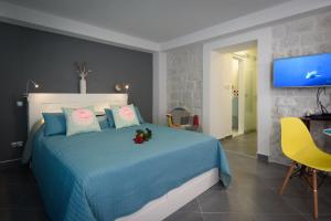 um quarto com uma cama azul e uma televisão em Studio Tironi em Trogir