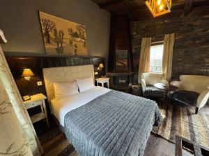 une chambre avec un lit et une chaise dans une pièce dans l'établissement Chalet Asteras tou Vorra, à Palaios Agios Athanasios