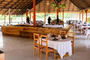 a restaurant with tables and chairs and a wooden boat at Resort Açude 