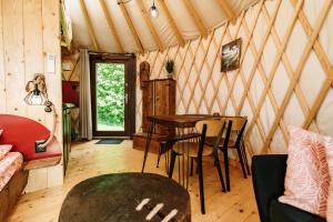 a room with a table and chairs in a yurt at Jurty za winklem ze strefą SPA in Rudnica