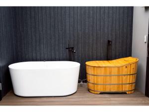 a bath tub and a wooden barrel in a bathroom at Kamogawa Sea Sauna Villa - Vacation STAY 45731v in Kawaguchi