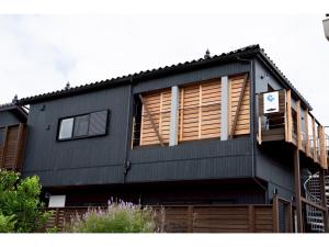a black house with wooden shuttered windows on it at Kamogawa Sea Sauna Villa - Vacation STAY 45731v in Kawaguchi