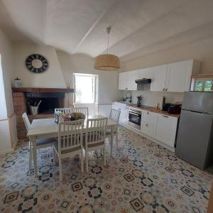 a kitchen with a table and chairs and a dining room at Maison en pierre avec piscine in Ribes
