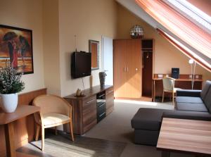 a living room with a couch and a tv at Park Residence in Garching bei München