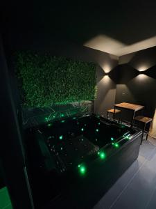 a hot tub in a room with a green wall at La Romantique in Bressuire