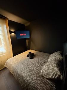 a bedroom with a bed with a television on the wall at La Romantique in Bressuire