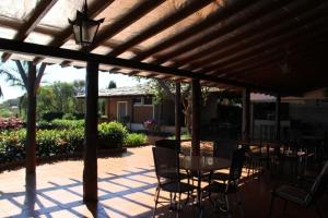 un patio avec une table et des chaises sous une pergola en bois dans l'établissement Chácara Vila Toscana,  5 autres photos