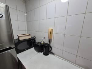 ein kleines Badezimmer mit Telefon und Mikrowelle in der Unterkunft Entrehoteles Suites in Santiago