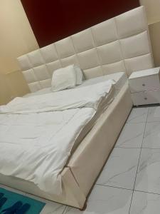 a white bed with a white headboard in a room at KIGALi GARDEN VILLA HOMES in Kigali +27 photos