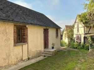 a small white building with a porch and a door at La Grange à Grains - Château-Renard in Château-Renard +38 photos