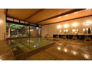 a large room with a swimming pool in a building at Osakaya Ryokan - Vacation STAY 37090v in Kusatsu +23 photos