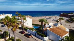 a view of a beach with palm trees and buildings at "Ancla-Blanca" Ocean View Duplex 2min Beach Cabo Roig - La Zenia in Orihuela Costa