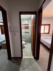 a room with a bathroom with a toilet and a bedroom at Ape beira-mar paraiso kitesurf in Cajueiro +37 photos