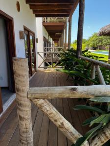 a wooden porch with a bench on a house at Ape beira-mar paraiso kitesurf in Cajueiro