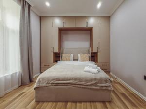 Un dormitorio con una cama grande con dos toallas encima. en Alta Hotel Baku, en Baku