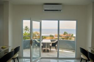 a dining room with a table and a view of the ocean at Hotel Midotel Seaview in Pointe-Noire