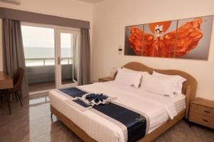 a bedroom with a bed and a window with the ocean at Hotel Midotel Seaview in Pointe-Noire