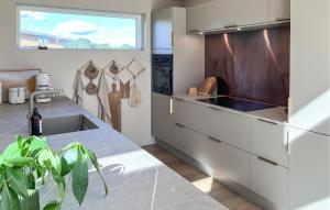 a kitchen with a sink and a large window at Nice Home In Hadsund With Sauna in Nørre Hurup