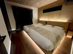 a large white bed in a bedroom with a window at Umenoyu Bettei - Vacation STAY 41988v in Dazaifu