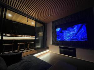 a living room with a large tv and a couch at Umenoyu Bettei - Vacation STAY 41988v in Dazaifu
