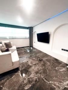 a living room with a couch and a flat screen tv at Cycladic Suite in Thessaloniki